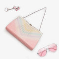 Pastel rainbow metallic Japanese silk clutch bag with silver grid and filigree clasp, shown in playful styled flatlay
