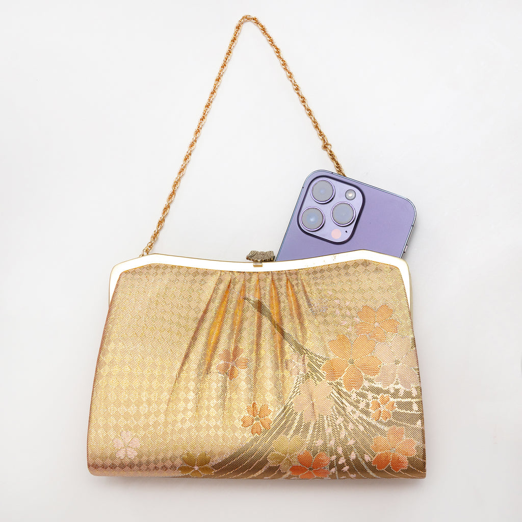 Gold vintage Japanese crane and cherry blossom silk clutch bag shown with iPhone 14 Pro Max for scale