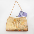 Gold vintage Japanese crane and cherry blossom silk clutch bag shown with iPhone 14 Pro Max for scale