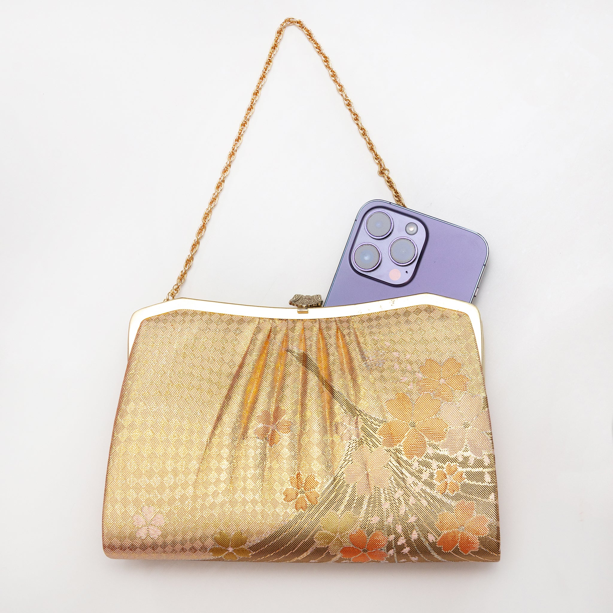 Gold vintage Japanese crane and cherry blossom silk clutch bag shown with iPhone 14 Pro Max for scale