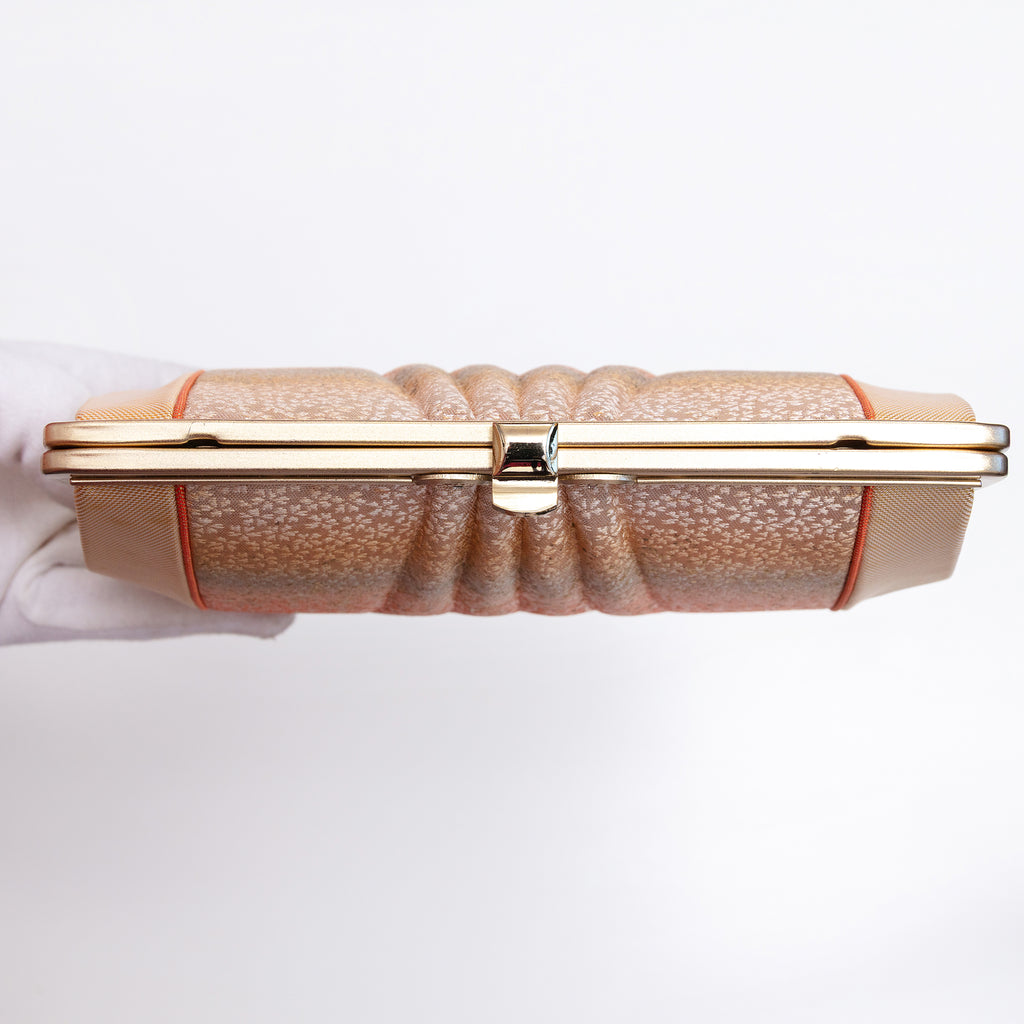 View of top of vintage clutch bag gold frame with the strap hinges and chain strap tucked inside the bag.