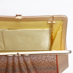 Close-up of fold-away chain hinge inside gold-tone metal frame, cream silk lining and internal pockets