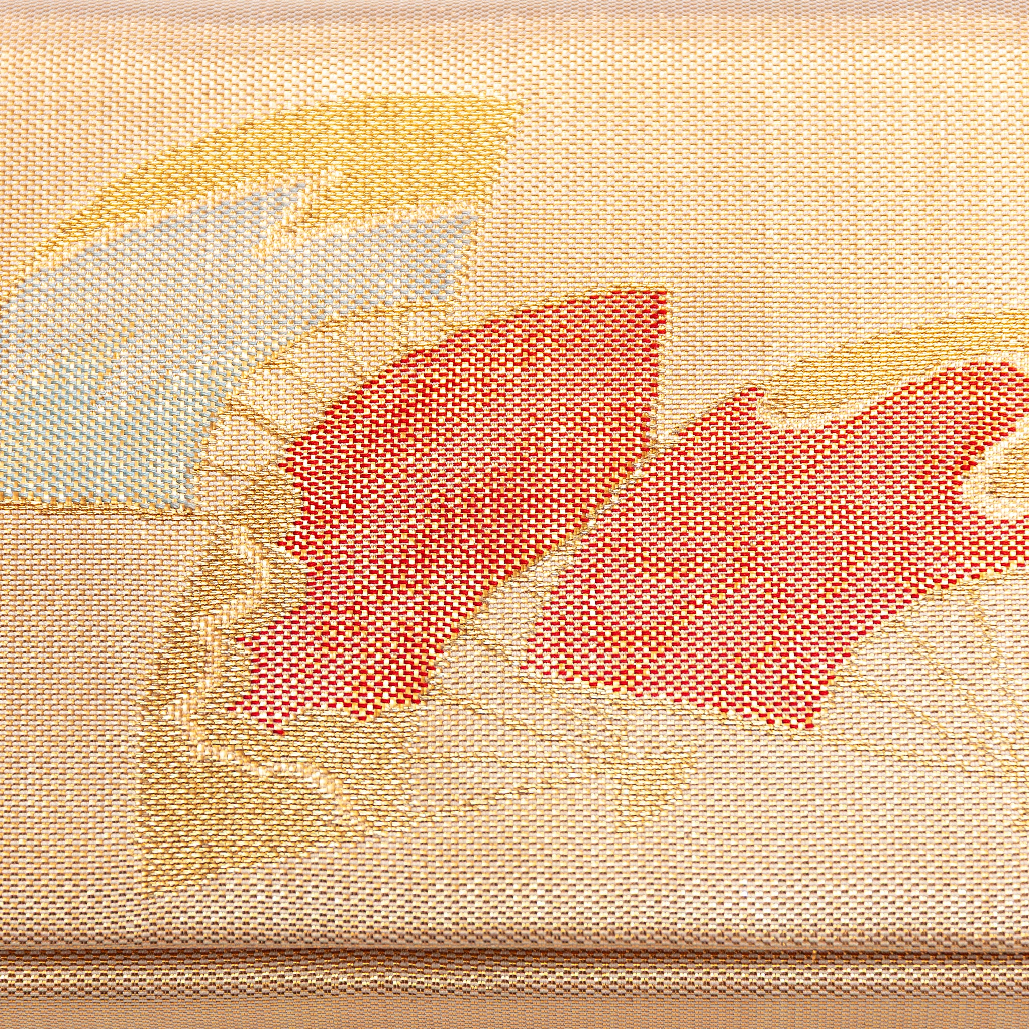 Close up detail of a vintage kimono silk clutch showing woven gold base and three Japanese fans in red, gold and silver.