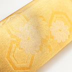 Close up of a vintage Japanese kimono silk clutch bag in metallic gold showing fortune hexagons and flowers.