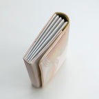 Side view of vintage Japanese clutch bag showing metallic silver folded edge.