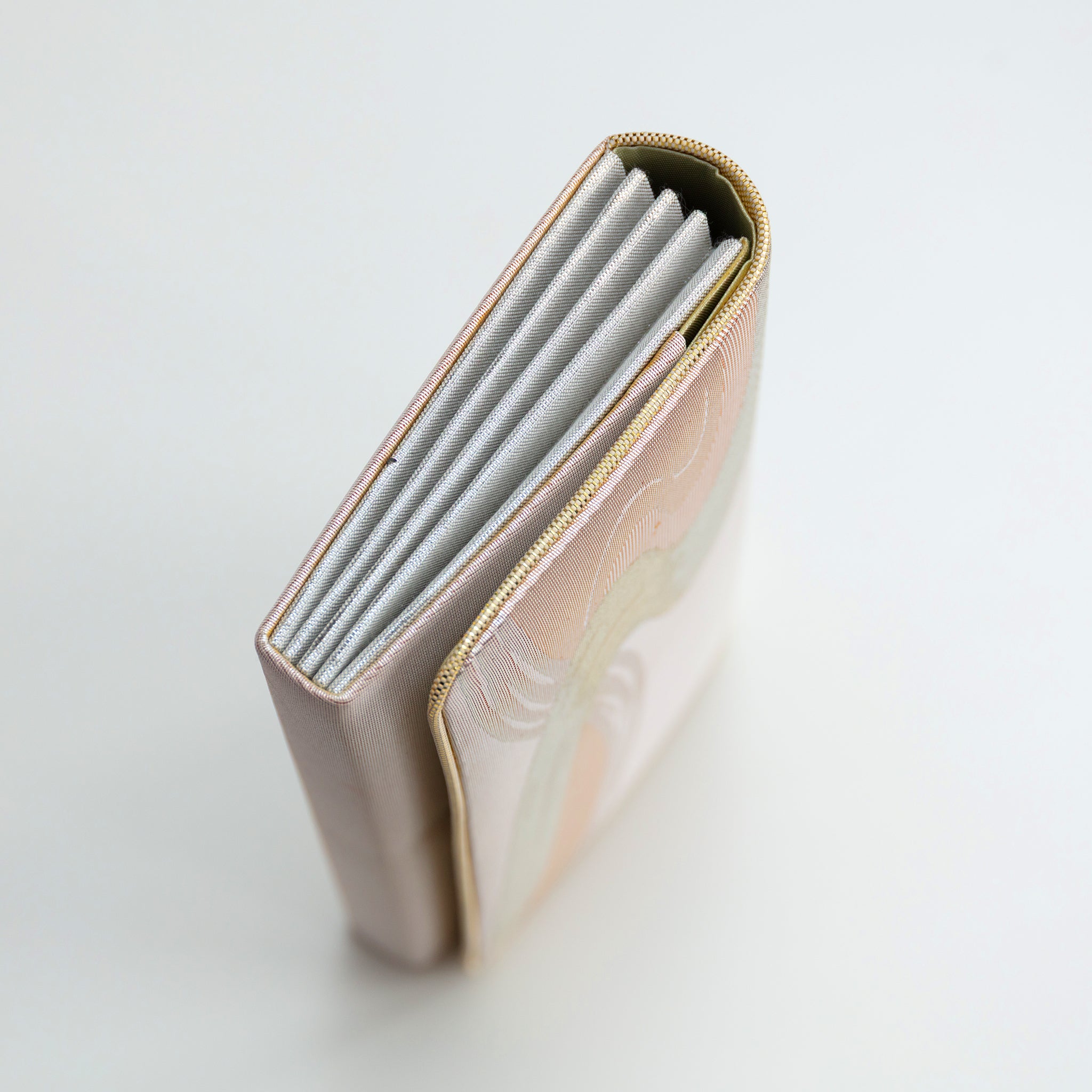 Side view of vintage Japanese clutch bag showing metallic silver folded edge.
