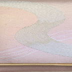 Close-up of iridescent rainbow river pattern on textured vintage Japanese kimono clutch fabric and detail of gold trim accent.