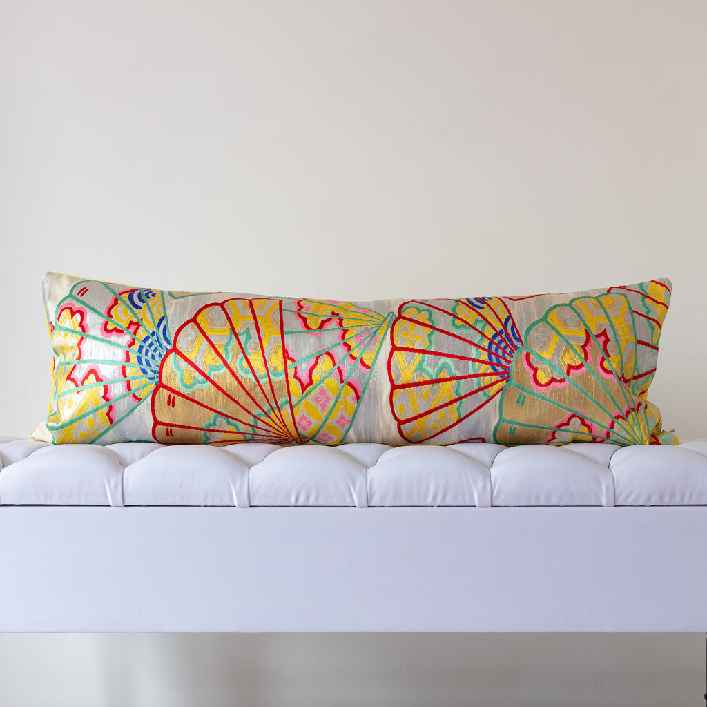Silver and yellow silk kimono bolster cushion with multicoloured open fans motifs in a neutral room