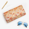 Gold red vintage Japanese silk clutch bag styled with blue sunglasses and gold pen