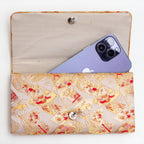 Gold red kimono silk clutch bag shown with iPhone 14 Pro Max for scale