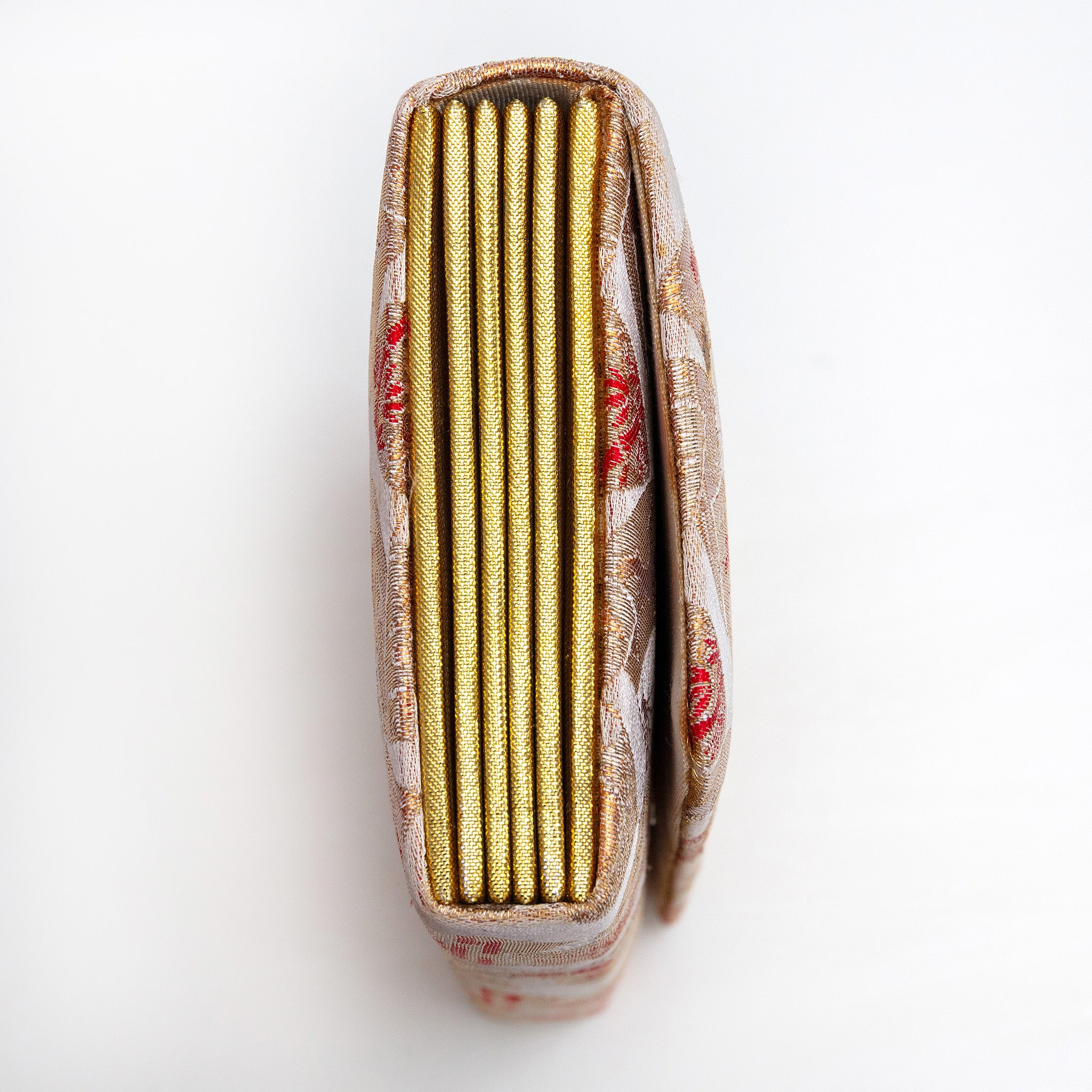 Side view of gold red envelope clutch showing folded concertina sides in bright gold.