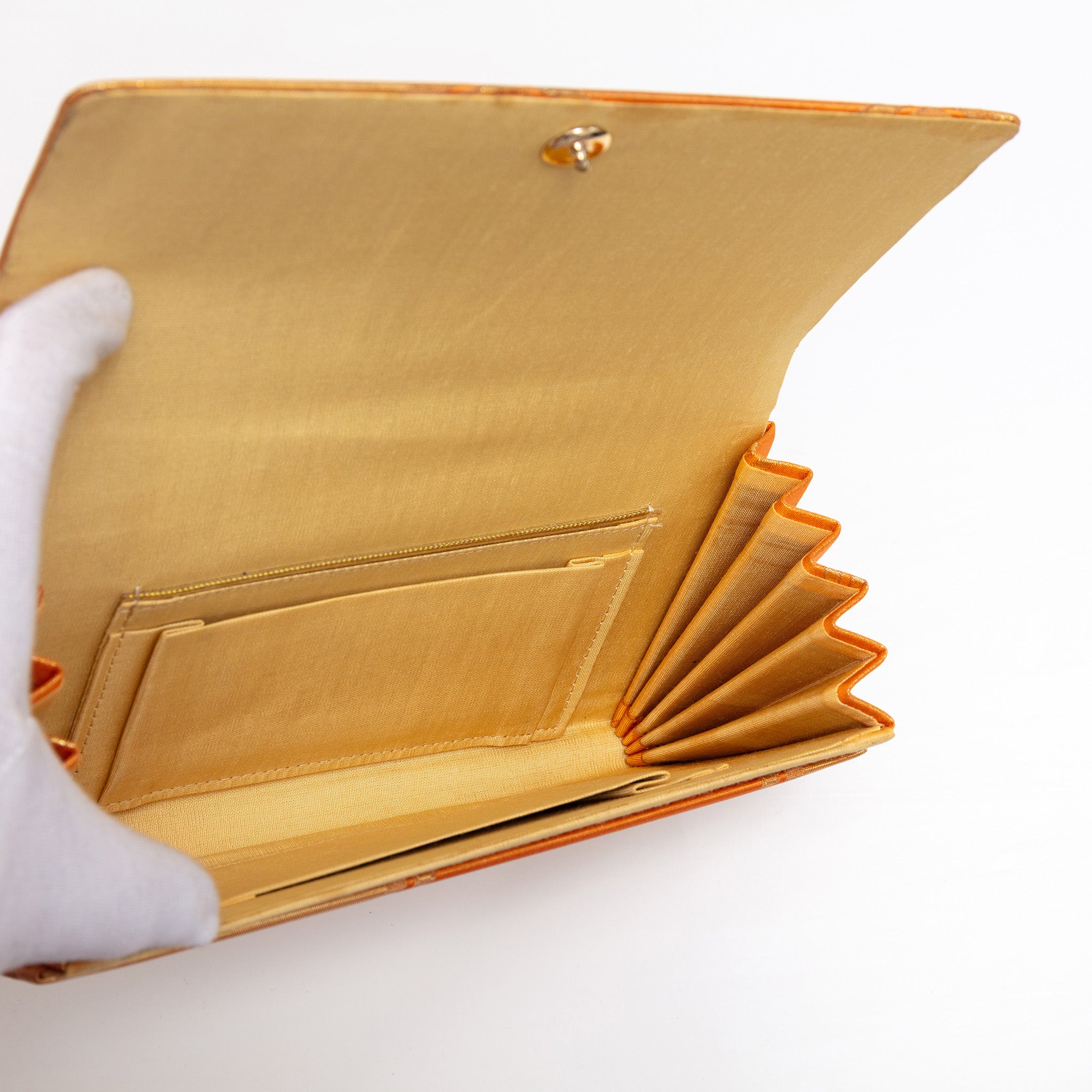 Open vintage Japanese clutch purse showing buttercream silk interior and stud fastening