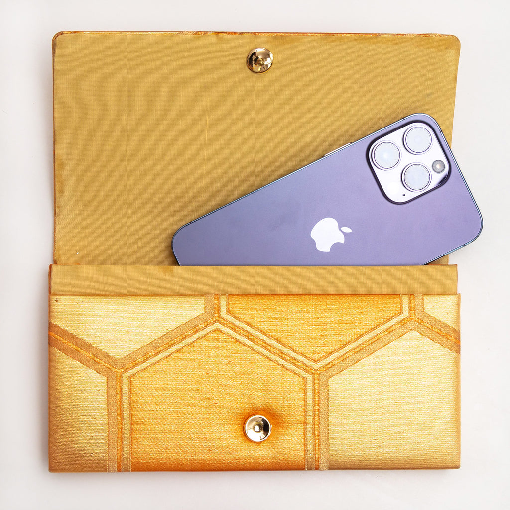 Gold kimono silk clutch bag shown with iPhone 14 Pro Max for scale