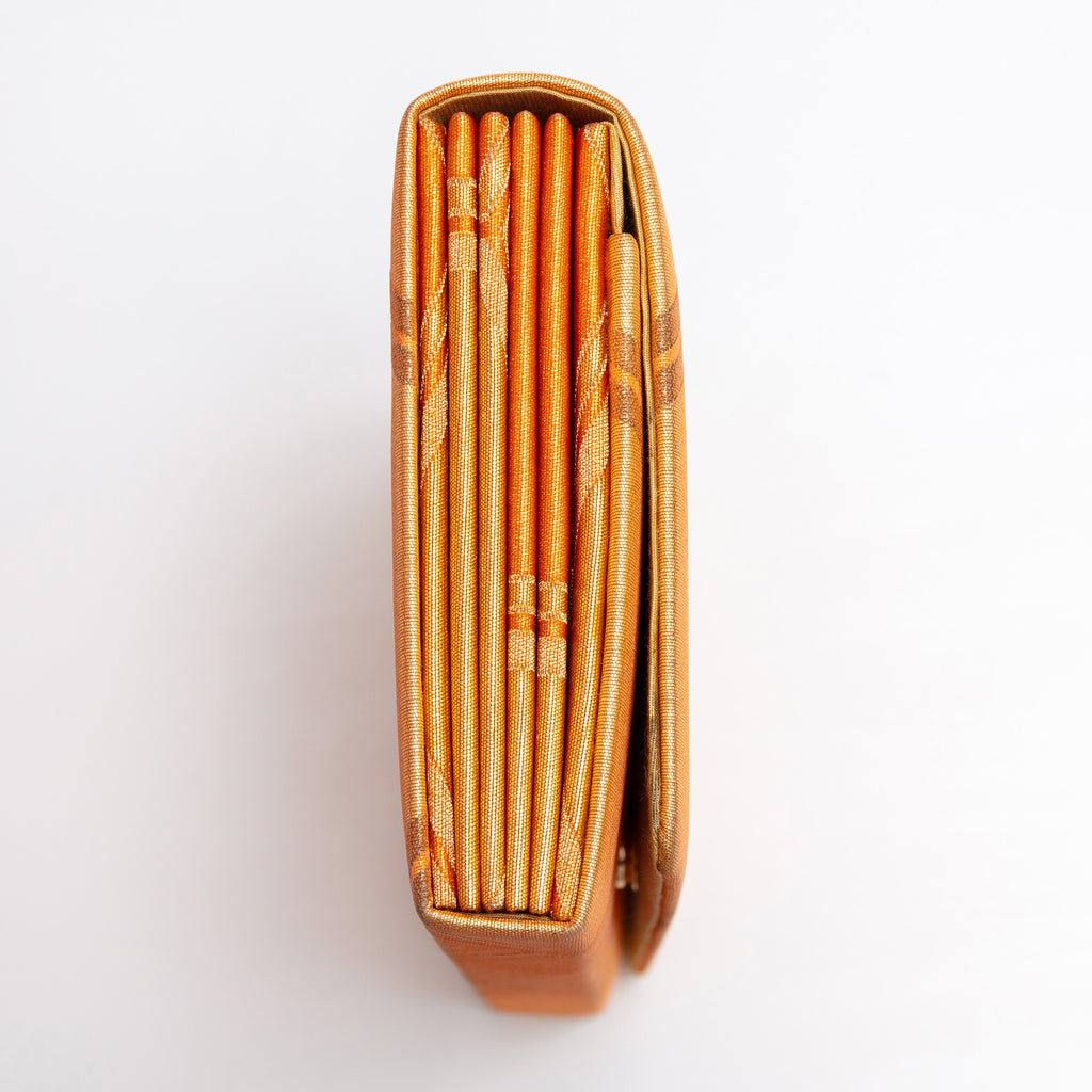 Side view of metallic orange and gold vintage Japanese envelope clutch showing folded construction