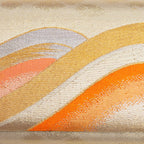 Close-up of layered orange, gold and cream wave design woven into kimono silk