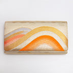 Front view of gold orange kimono silk clutch bag with layered wave pattern
