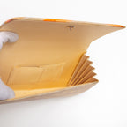 Open gold orange clutch bag showing cream silk lining and interior pocket (feint marks on pocket)