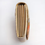 Side view of gold orange envelope clutch showing folded metallic gold concertina sides