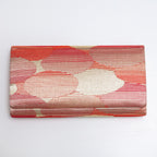 Front view of red-gold kimono silk clutch bag with abstract cloud pattern