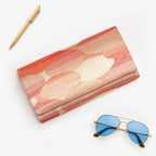 Red-gold vintage Japanese silk clutch bag, abstract cloud pattern, styled with sunglasses and gold pen