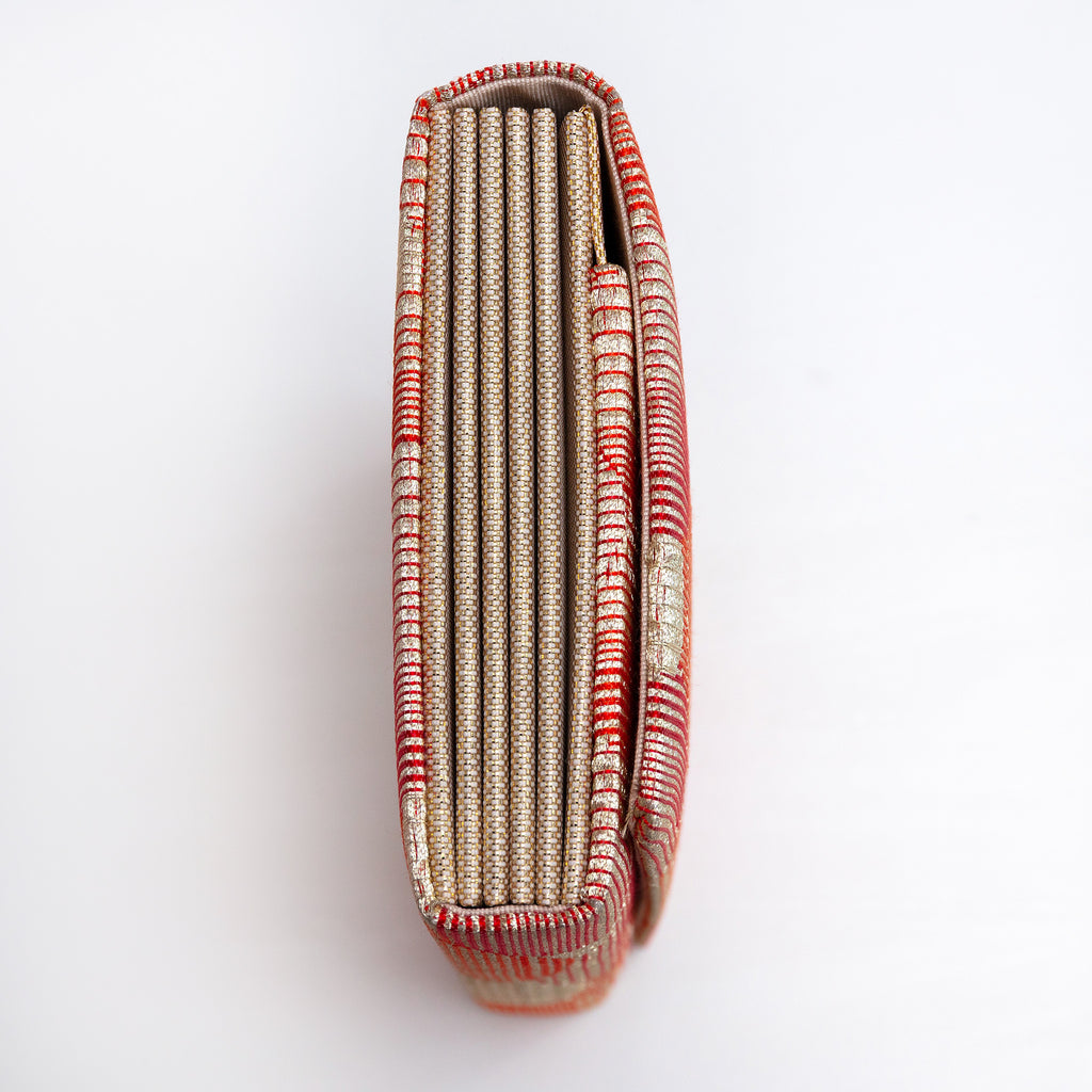 Side view of red-gold envelope clutch showing folded concertina sides in gold and cream silk.