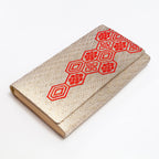 Gold vintage Japanese silk clutch bag with red Kikkō hexagon pattern, shown at an angle