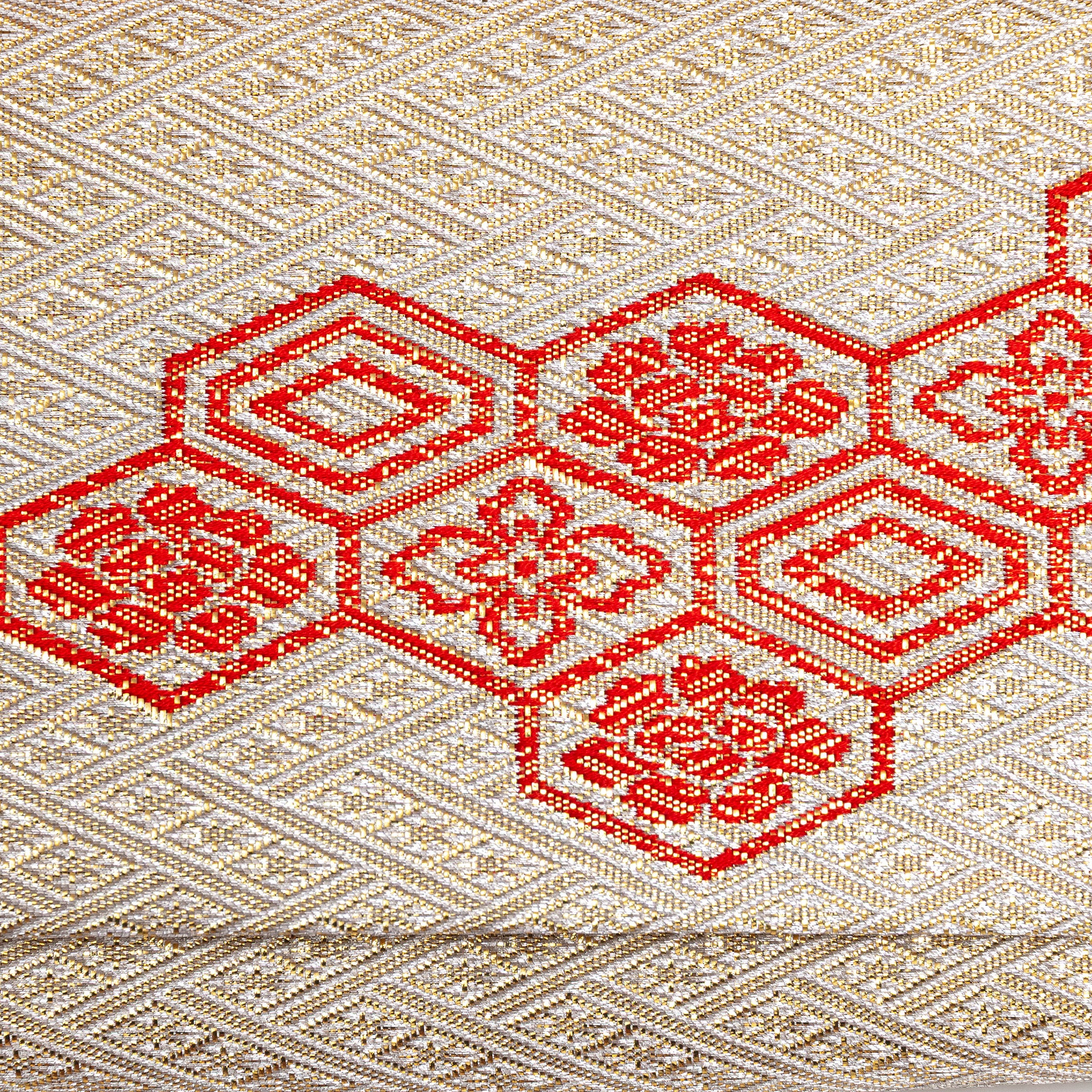 Close-up of red Kikkō hexagon pattern woven into gold metallic kimono silk