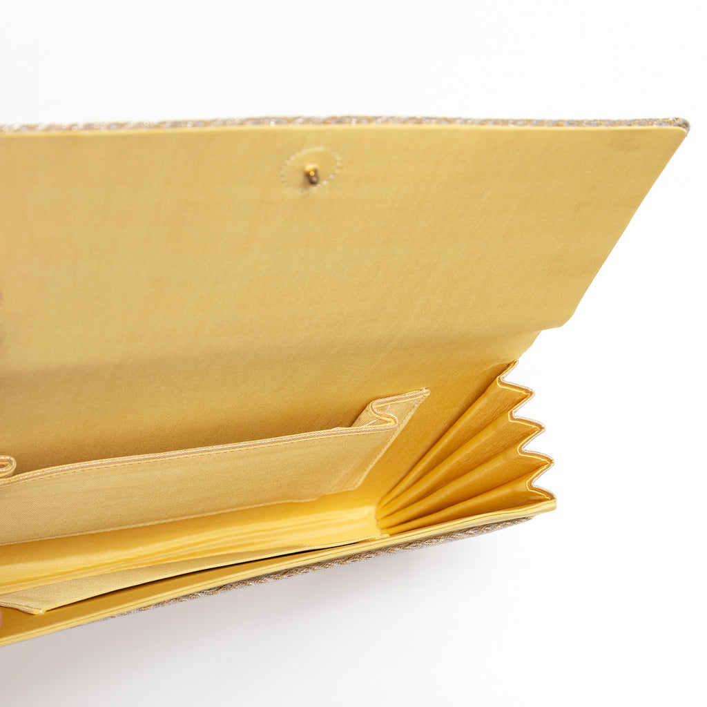 Open gold kimono silk clutch bag showing buttercream silk lining and interior pockets