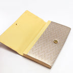 Open vintage Japanese clutch purse showing gold silk interior and snap fastening