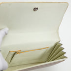 Cream silk lining of a vintage Japanese silk clutch bag held open by gloved hand showing interior pocket trimmed in gold.