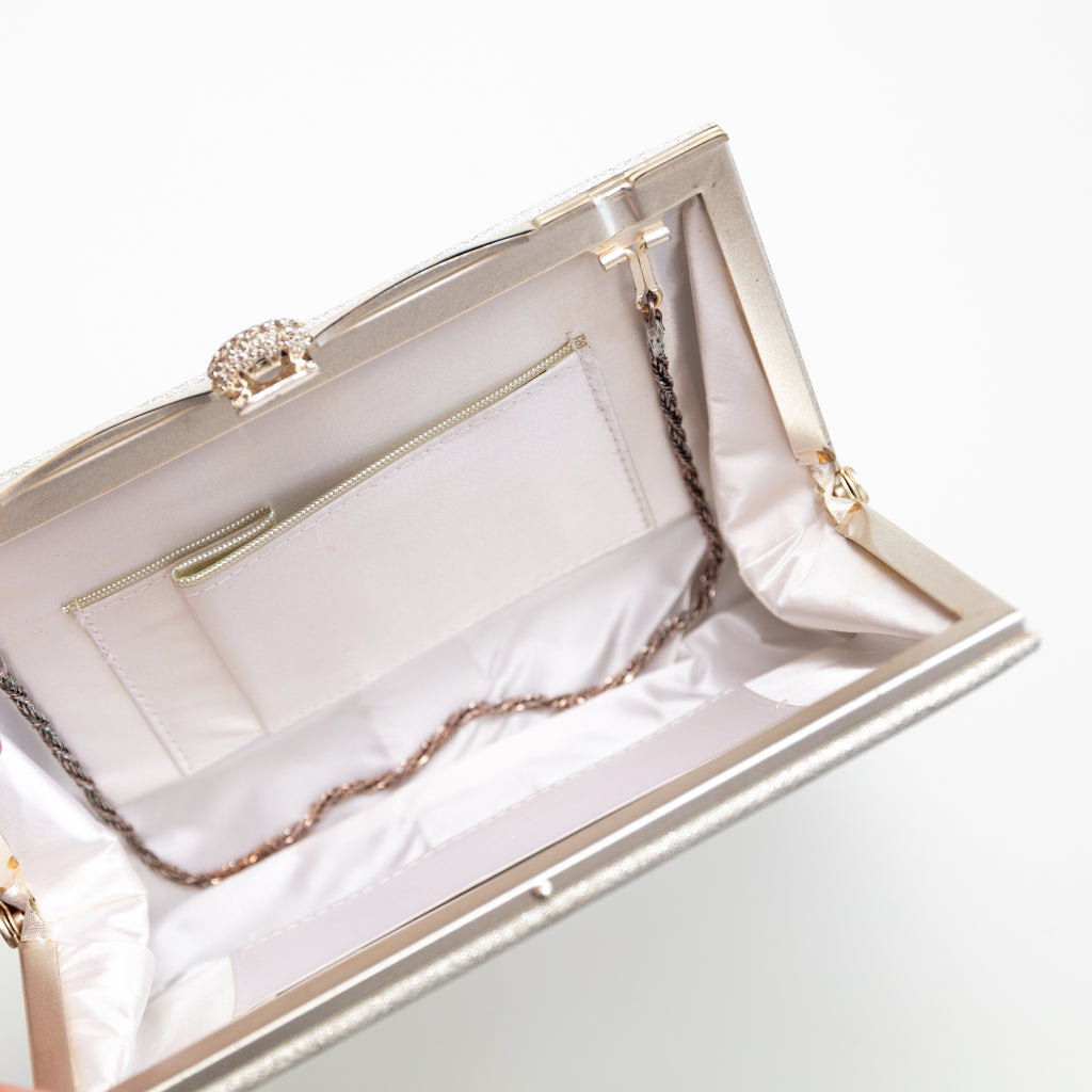 Interior view of vintage Japanese silk clutch bag showing white silk lining, internal pocket and silver chain strap tucked inside.
