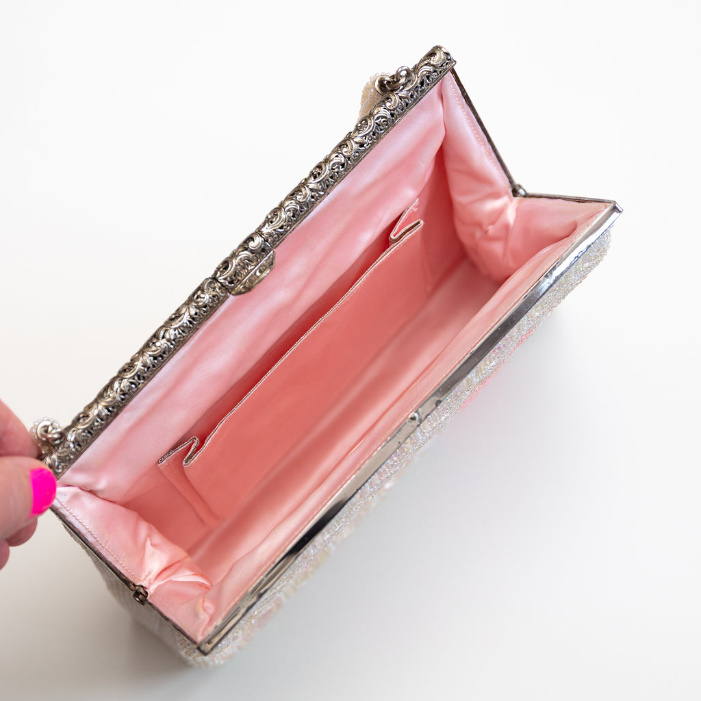 Interior of vintage Japanese beaded handbag with pink silk lining and interior pocket with silver trim