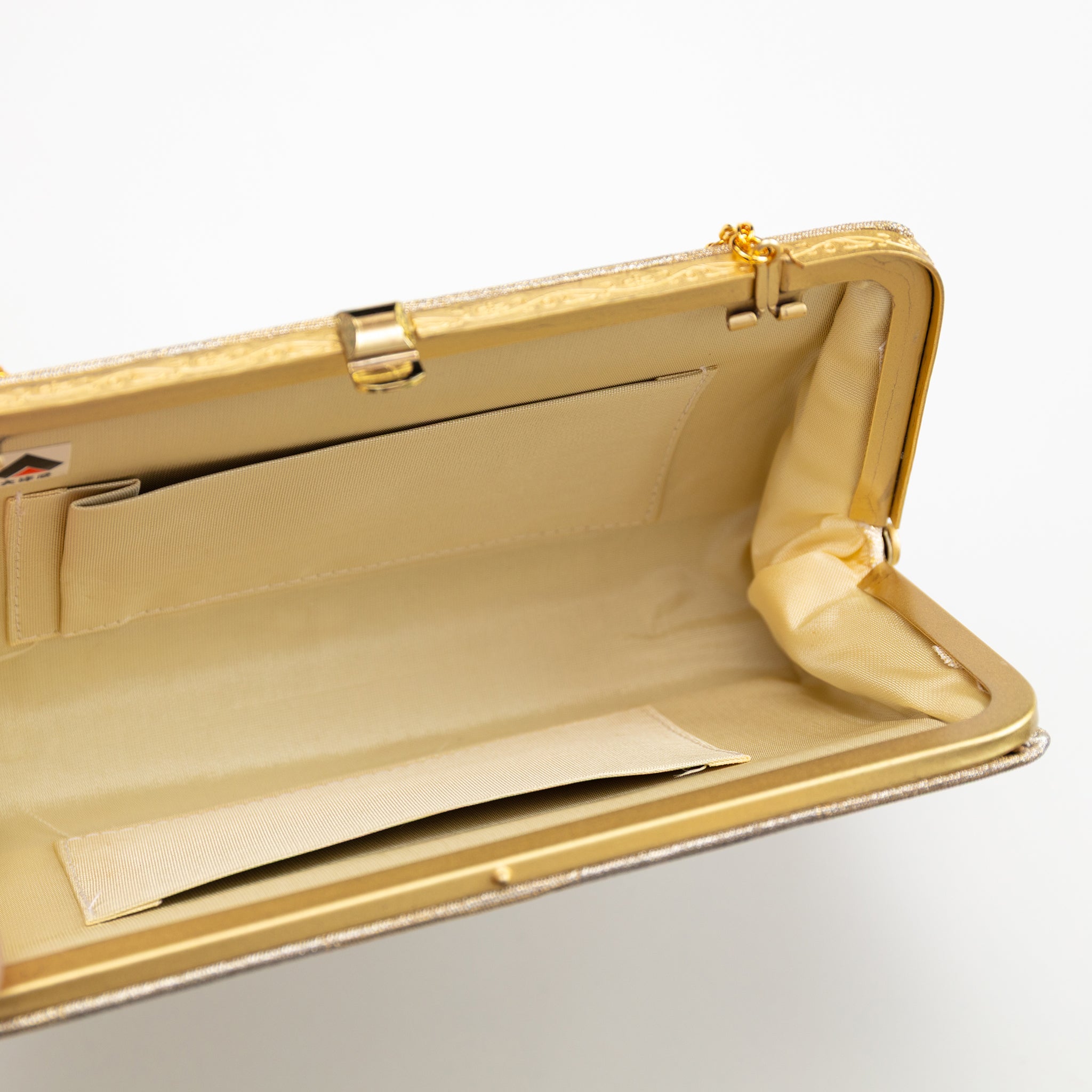 Interior view of gold vintage Japanese clutch bag showing cream silk lining and two internal pockets