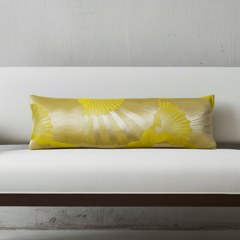 Long bolster cushion crafted from chartreuse vintage Japanese Maru obi silk with metallic gold fan motif, styled on a neutral bench.