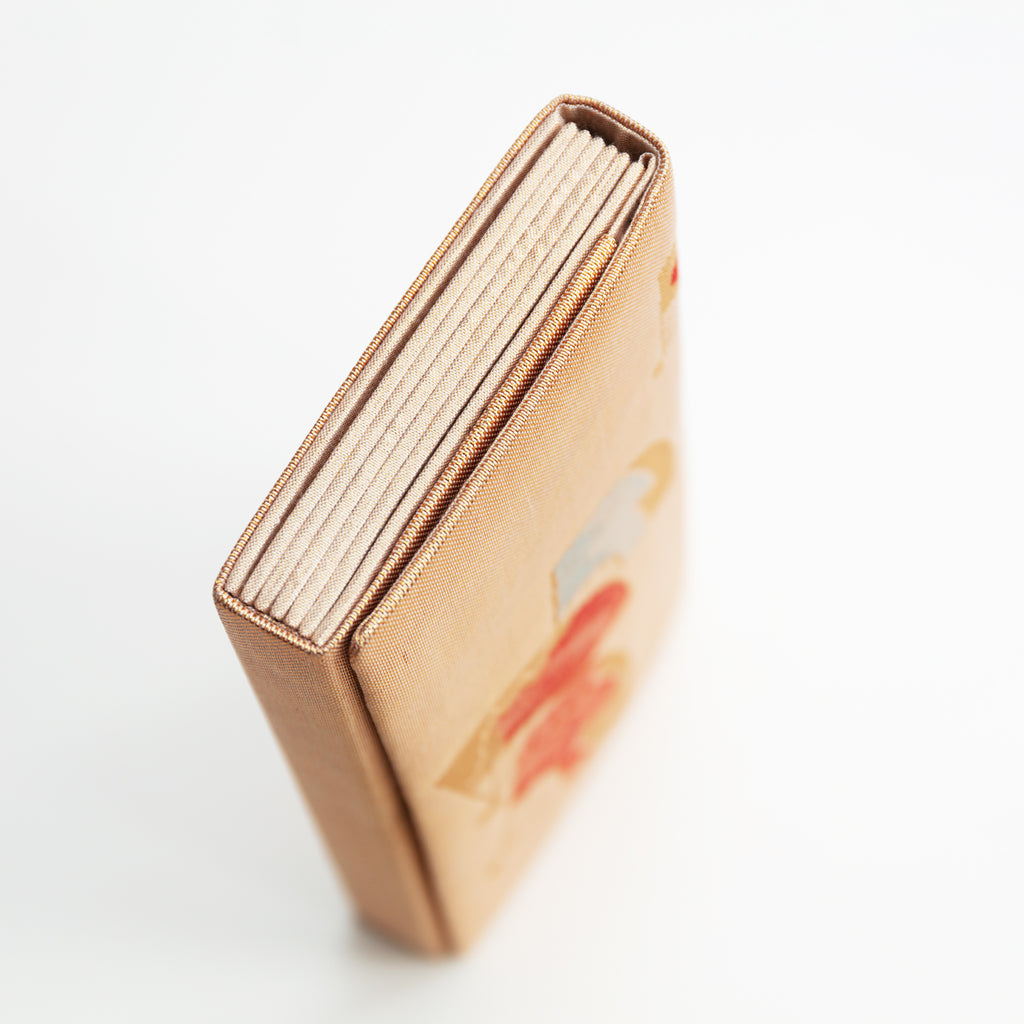 Side view of a vintage Japanese silk clutch bag showing gold folded side panel.