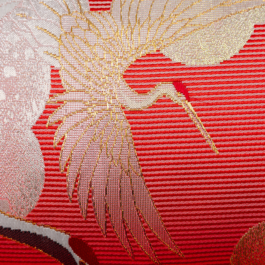 Close-up of the richly textured purple velvet backing and intricate silk crane embroidery on the pillow's edge detail.