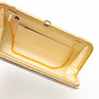 Interior view of gold vintage Japanese silk clutch bag, strap hinges turned in to tuck gold chain strap inside the bag