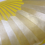 Close-up of the pillow's golden fan pattern stitched onto chartreuse silk, highlighting intricate embroidery and rich