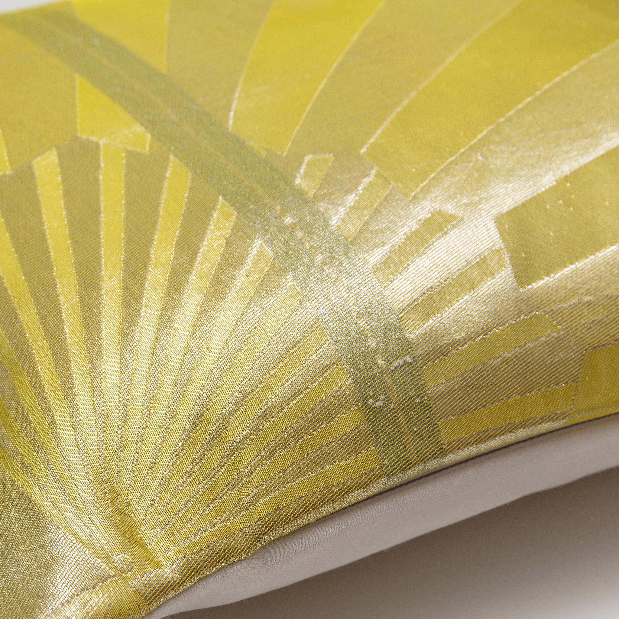 Close-up of the gold fans and vintage obi pattern embroidered on the silk pillow’s textured surface from a slightly angled