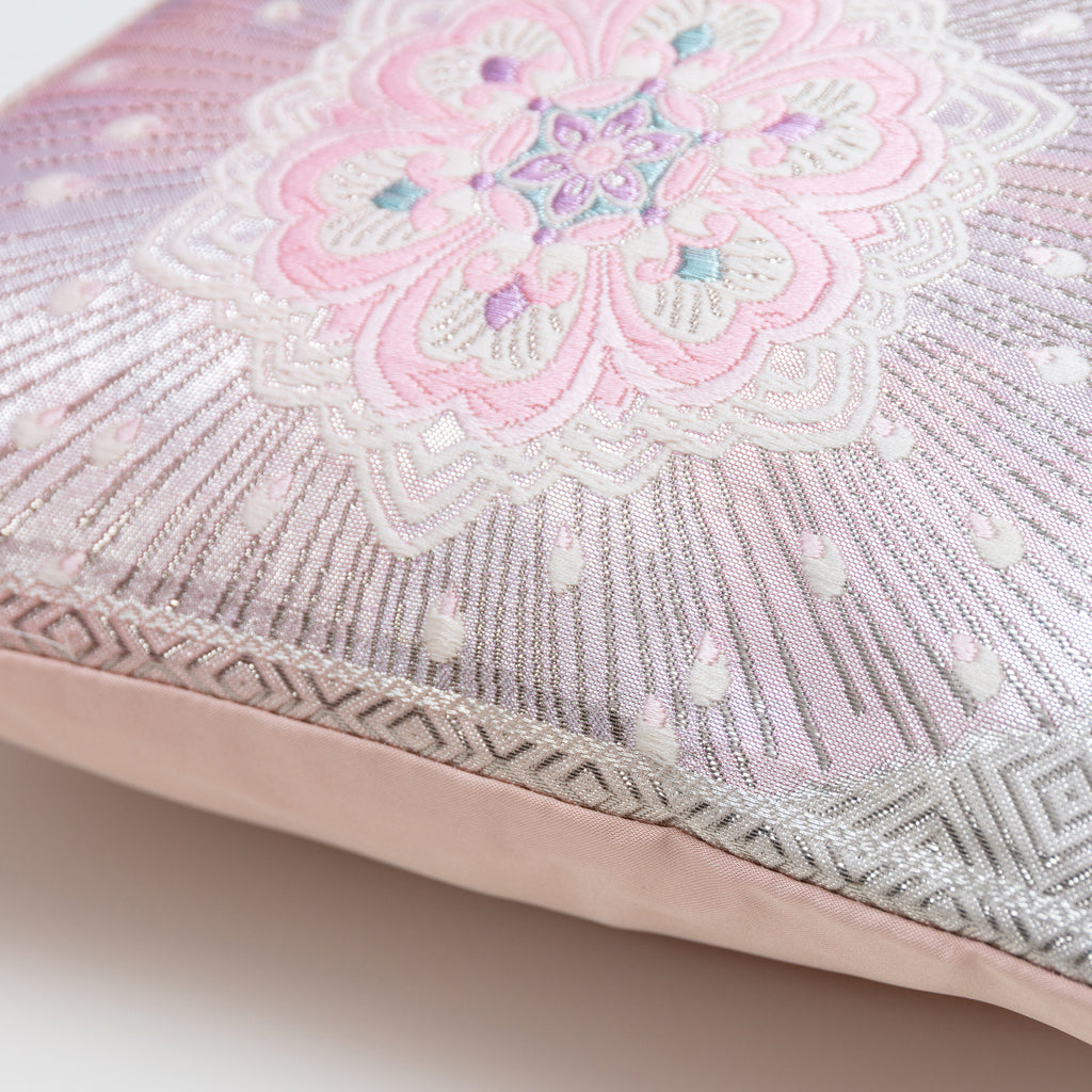 Detail of edge of obi cushion showing a silver border, pink flower motif and pink back.