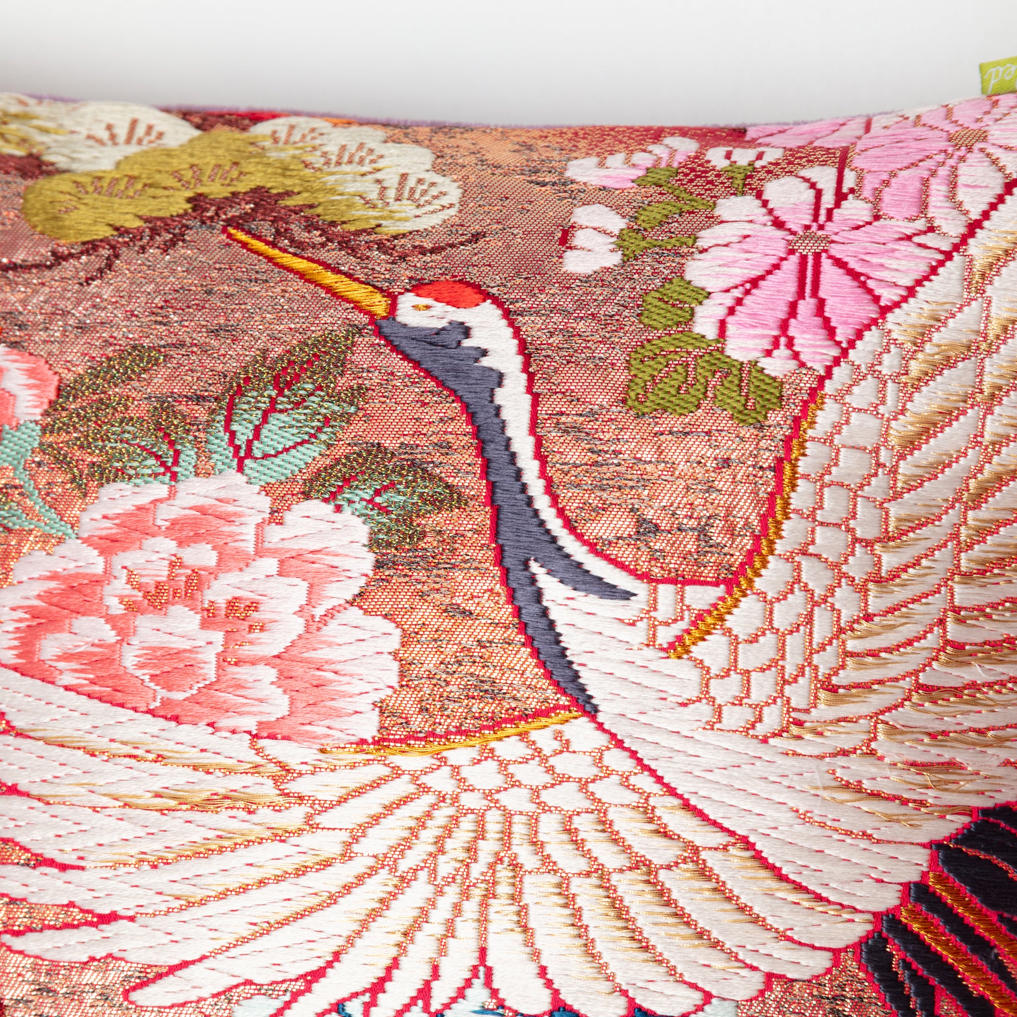 Close-up of purple velvet trim and subtle embroidered cherry blossom details along the pink ombre fabric edge of the bolster