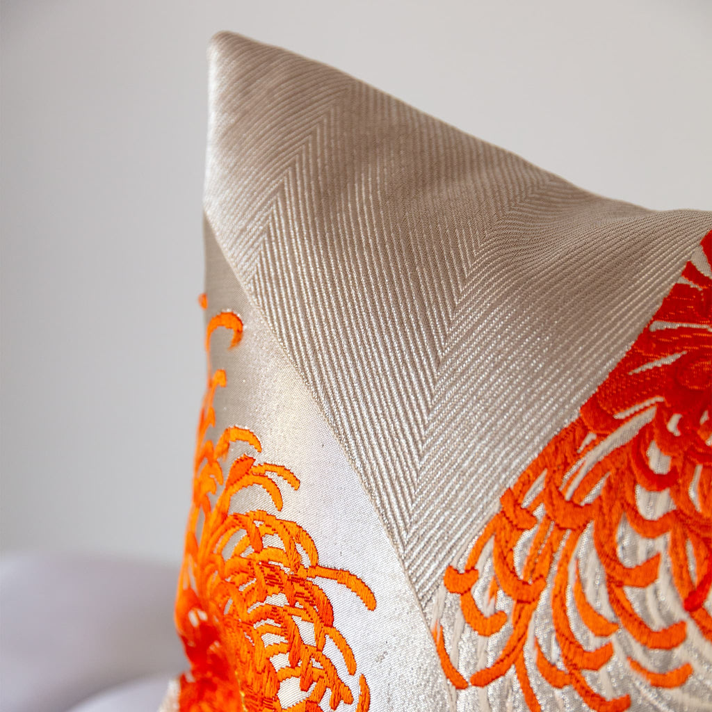 Kiku chrysanthemum petals in flame and burnt orange, extreme close-up of corner of vintage Japanese obi silk weave