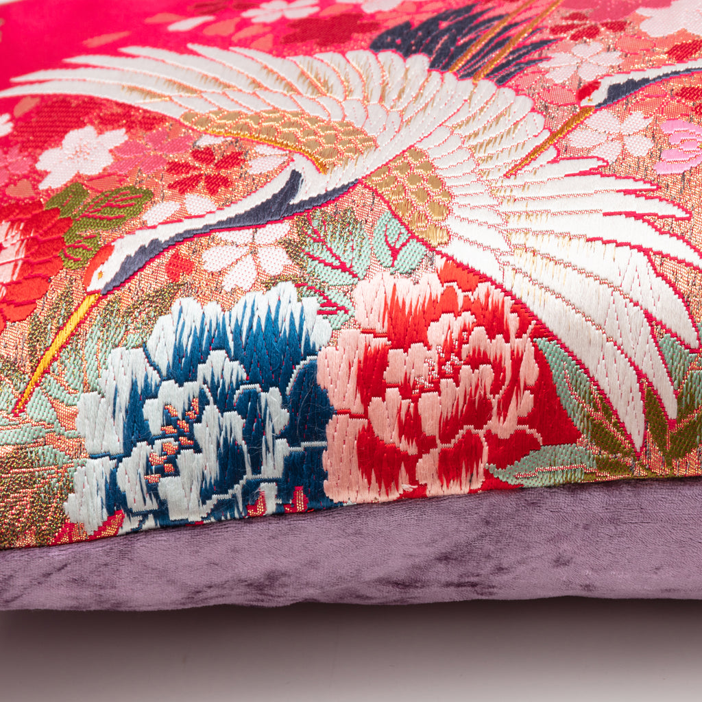 Close-up of the vibrant red silk fabric and detailed purple velvet embroidery on the Flying Cranes design of the bolster