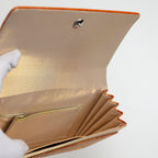Interior view of a vintage Japanese silk clutch bag being held open by a gloved hand showing the metallic gold silk lining and the interior pockets.