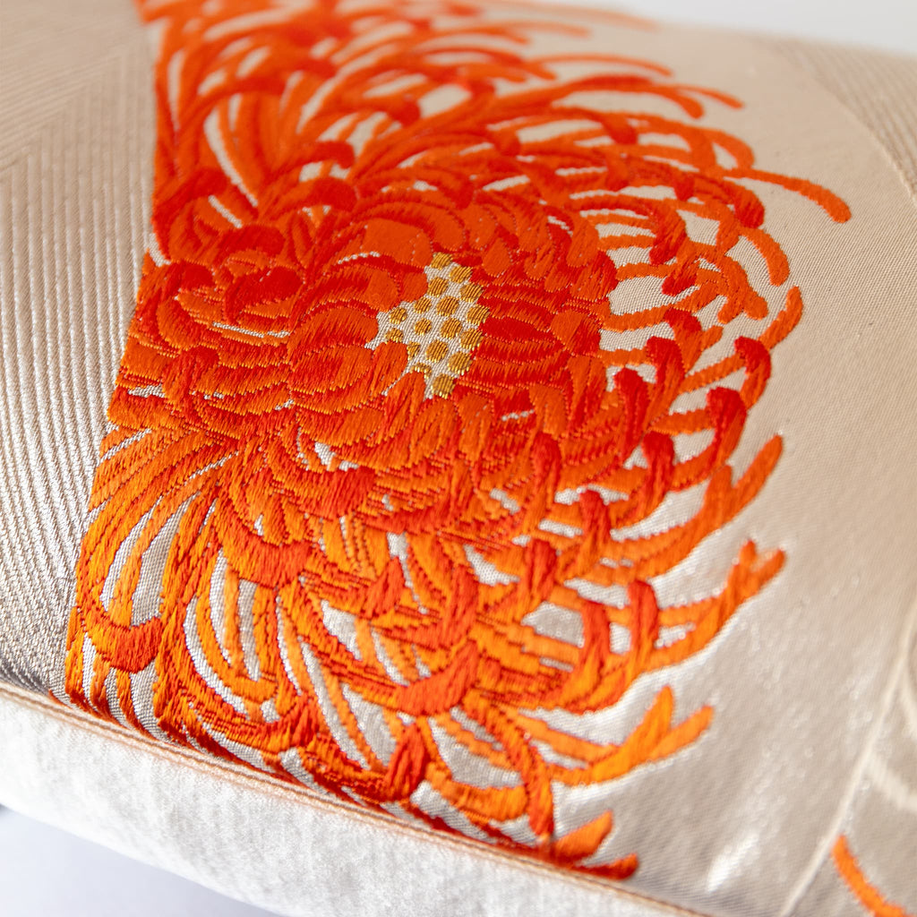 Spider chrysanthemum bloom in flame orange with gilt woven centre, close-up detail of vintage Japanese Fukuro Obi silk