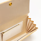View looking inside a vintage Japanese gold clutch bag showing an interior pocket with zip fastening.