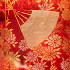 close up of vintage kimono silk uchikake with gold fans and flowers over red