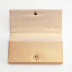 Gold vintage silk envelope clutch bag with the flap open to show the silk lining inside and the metal fastener. 