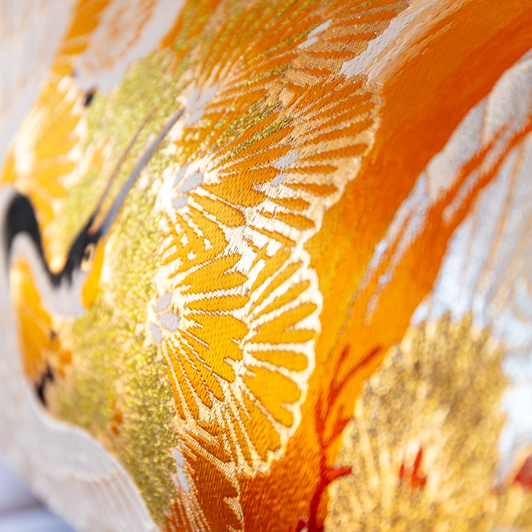 Metallic gold stylised pine fan motif close-up, golden Japanese Maru Obi silk bolster cushion