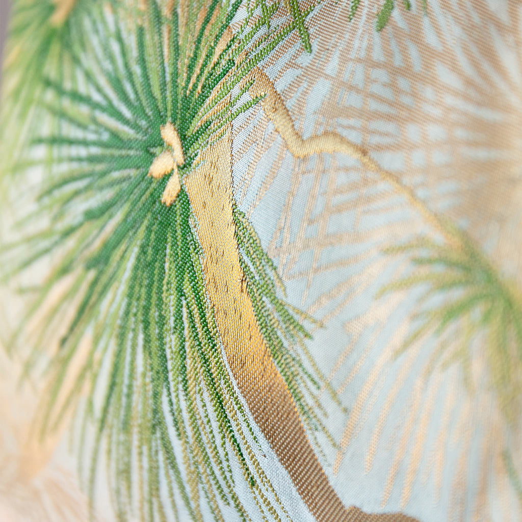 Detail of green pine motif on pale blue and beige vintage Japanese obi silk